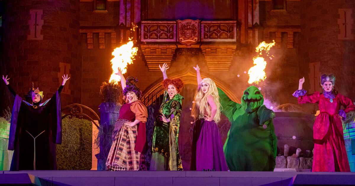 Photo of Disney villains performing in the Hocus Pocus Villains Spelltacular stage show. L-R: Evil Queen, Mary Sanderson, Winnie Sanderson, Sarah Sanderson, Oogie Bookie, and Lady Tremaine.