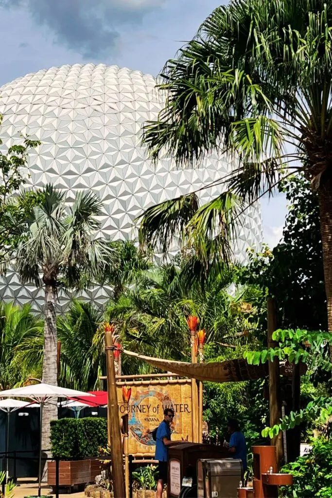 Photo of the entrance to Journey of Water ~ Inspired by Moana at Epcot, with Spaceship Earth in the background.