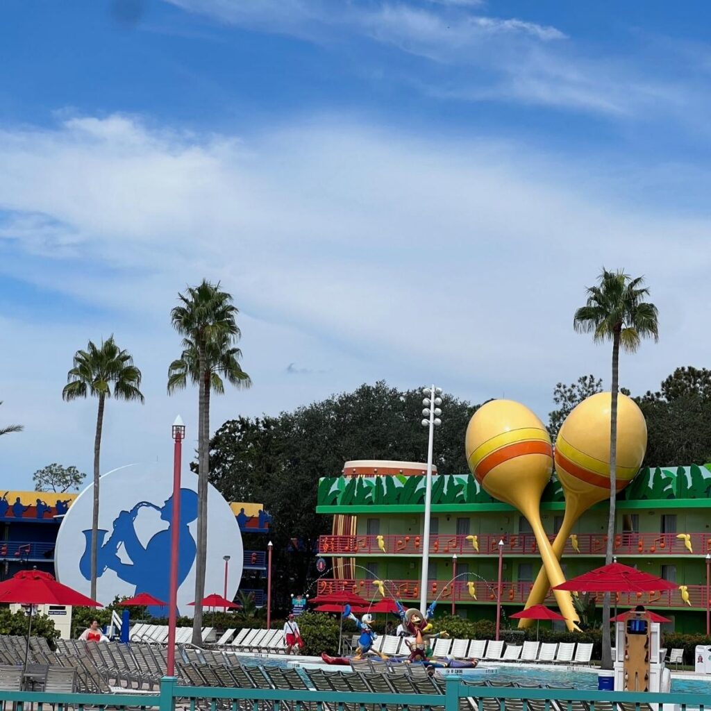 Photo of the main pool at All-Star Music resort with the Calypso and Jazz buildings in the background.