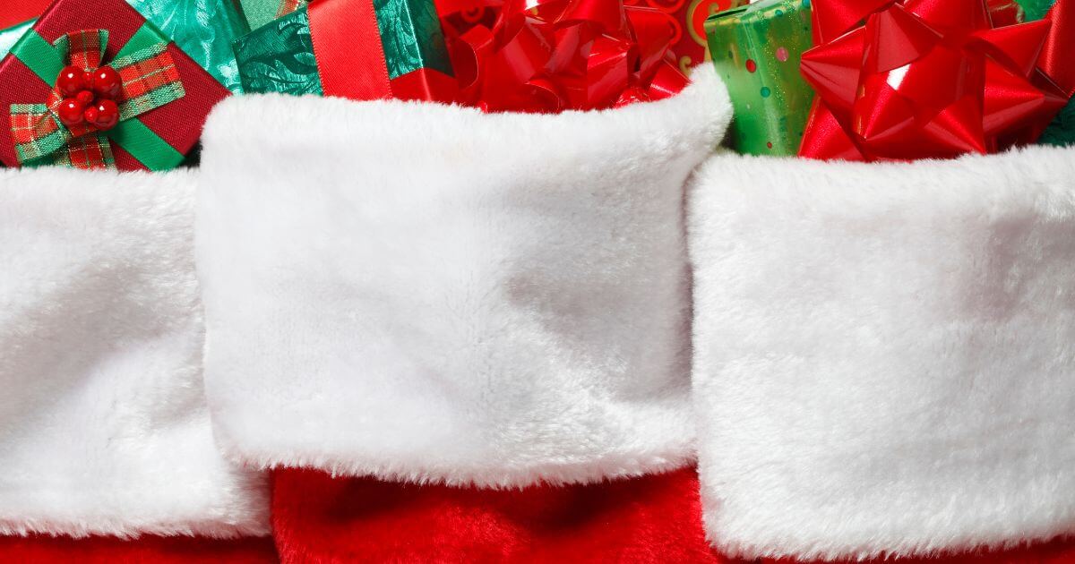 Closeup photo of three Christmas stockings stuffed with presents.
