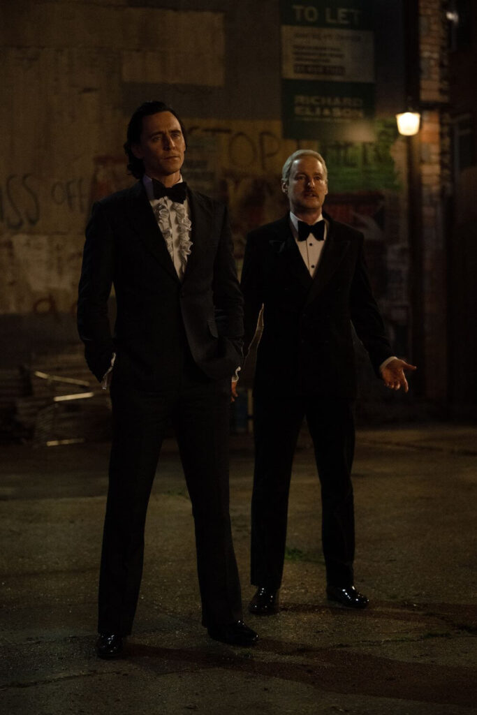 Photo still featuring (L-R) Tom Hiddleston as Loki and Owen Wilson as Mobius in Marvel Studios' LOKI, Season 2, episode 2. They are both dressed in 70s tuxedos.