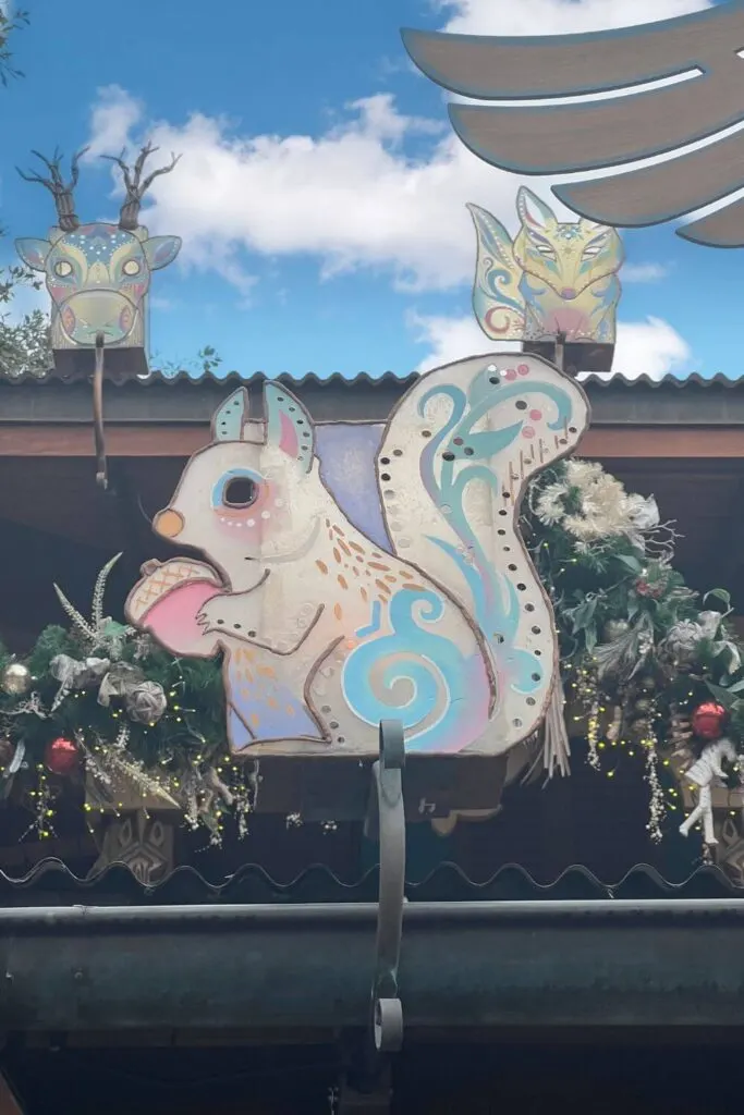 Photo of wintery animals in white, pink, blue, and purple amidst Christmas decor at Animal Kingdom.