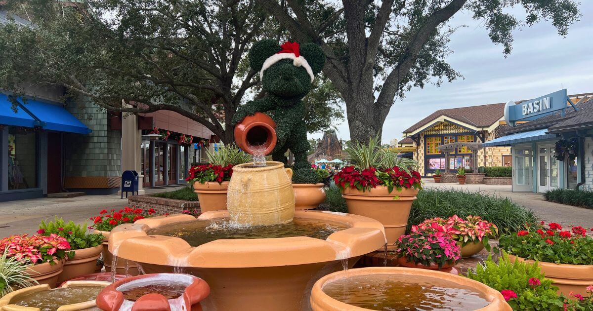 Photo of a Santa Mickey topiary fountain between World of Disney and Basin stores in Disney Springs.