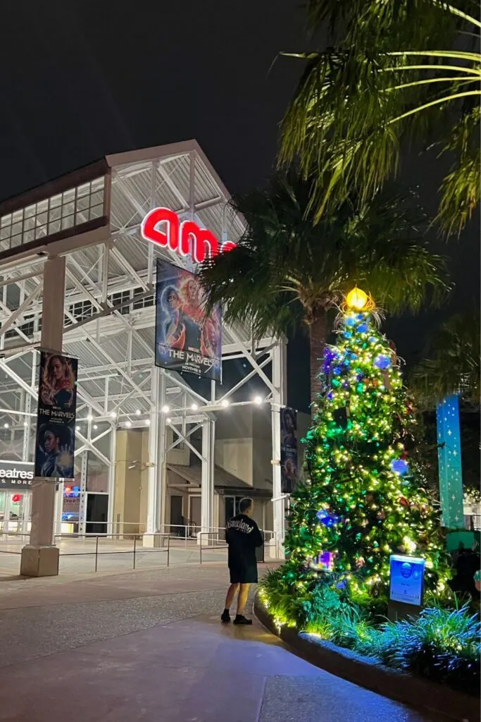 Photo of a Christmas tree lit up at night outside the AMC movie theater in Disney Springs.