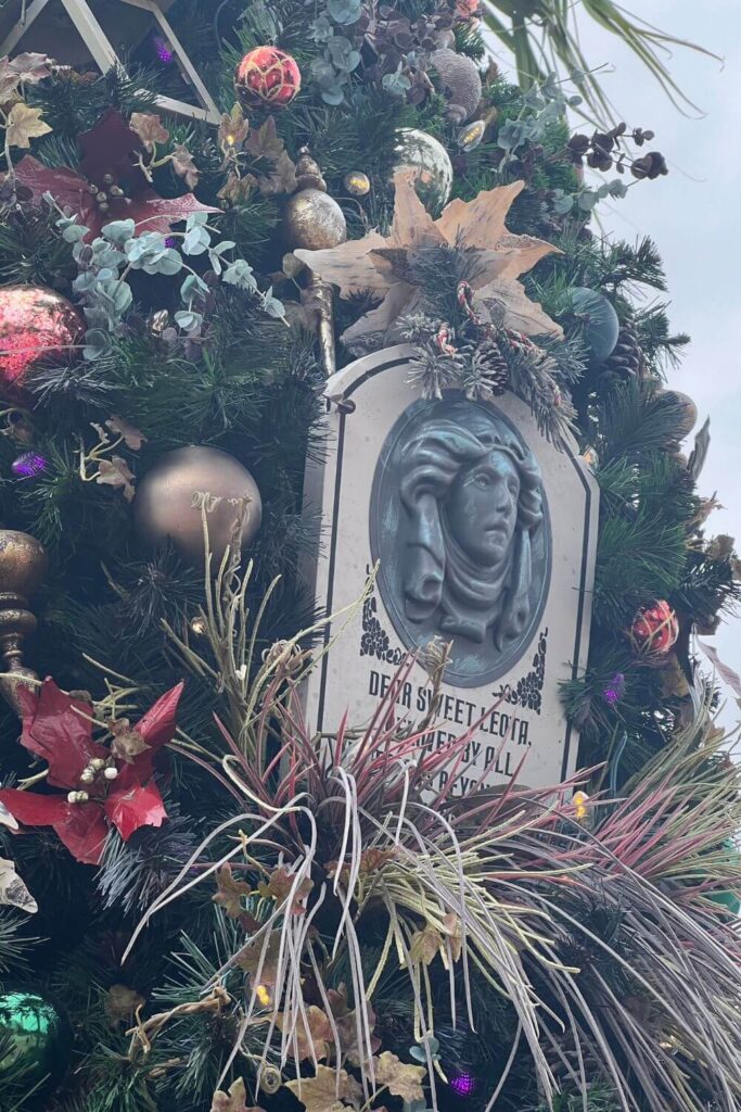 Closeup of a Madame Leota gravestone ornament on the Haunted Mansion tree on Disney Springs Christmas Tree Trail.