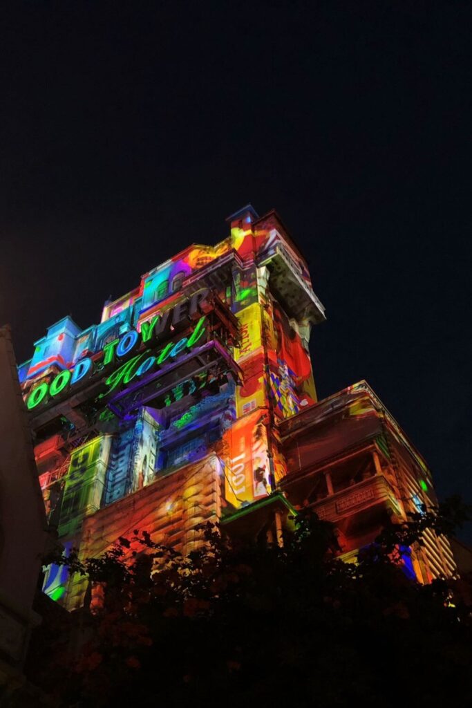 Photo of the Hollywood Tower Hotel at night during the Christmas season, with a holiday themed projection show on the building.