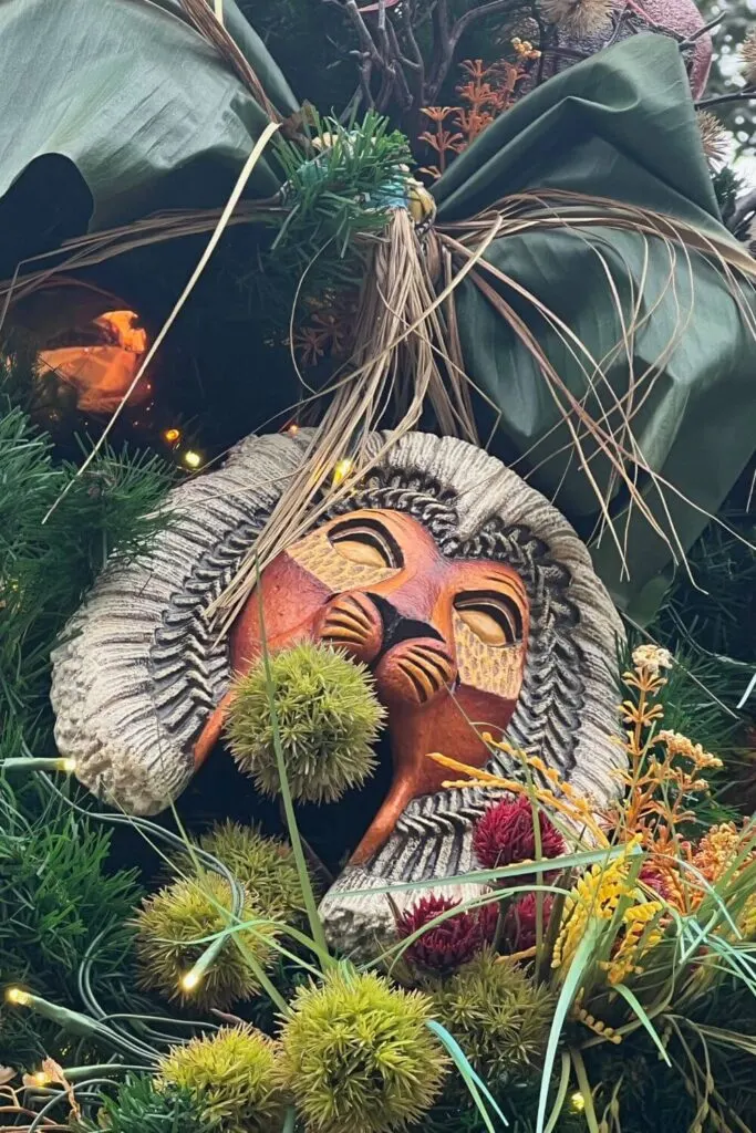 Closeup of a wooden lion mask ornament.