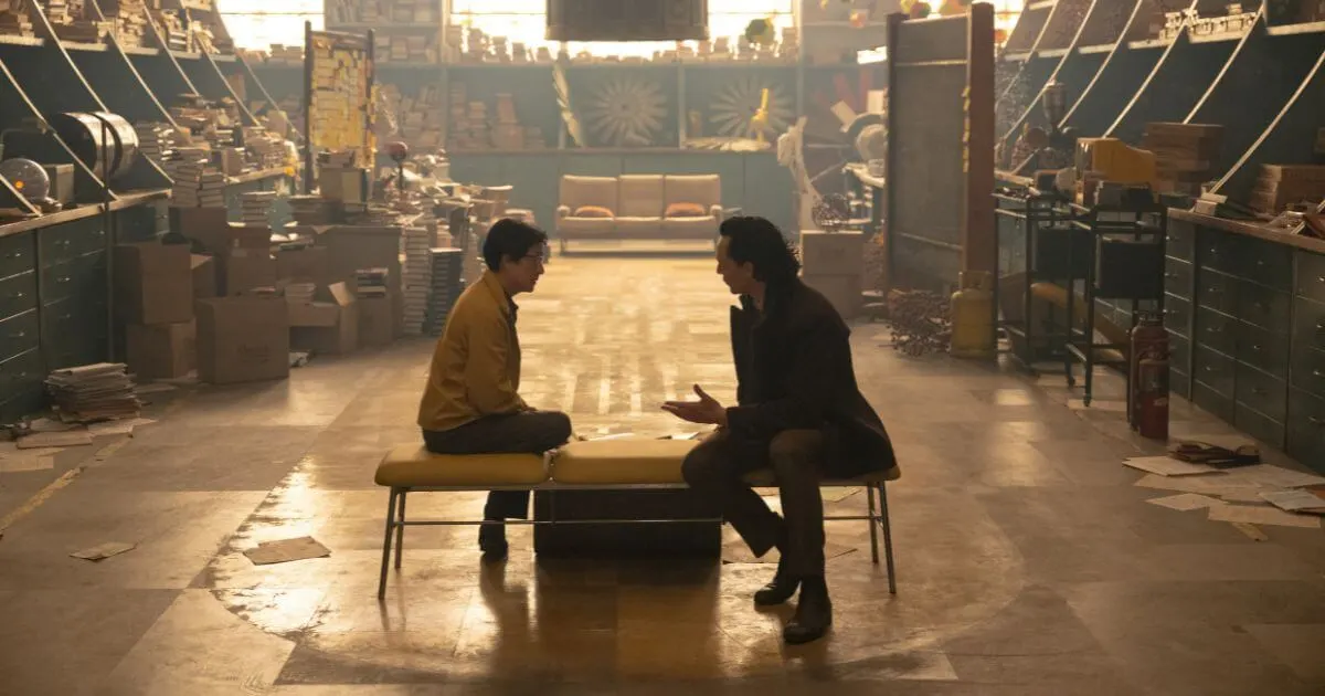 Photo still of (L-R): Ke Huy Quan as A.D. Doug (aka O.B.) and Tom Hiddleston as Loki in Marvel Studios' LOKI, Season 2, episode 5, as they both sit on a bench inside A.D. Doug, aka OB's, lab.
