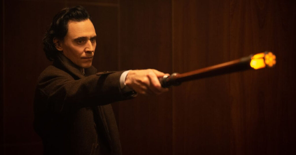Photo still of Tom Hiddleston as Loki in Marvel Studios' LOKI, Season 2, episode, as he points a time stick.