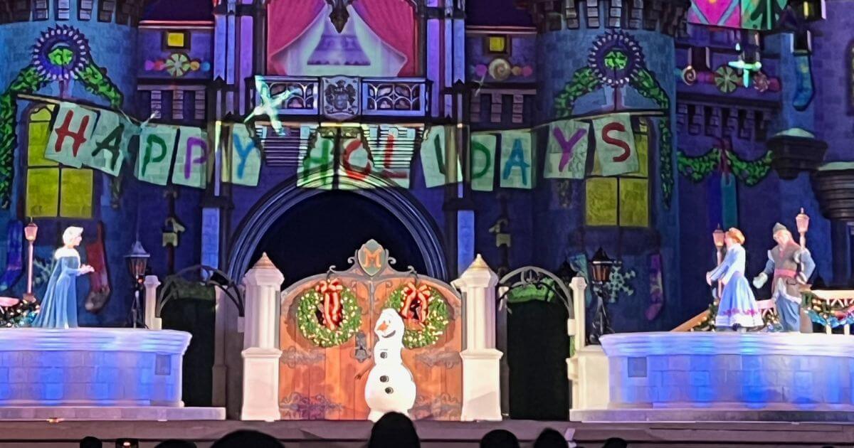 Photo of a scene from the Frozen Holiday Surprise show at Magic Kingdom featuring (L-R) Elsa, Olaf, Anna, and Kristoff.