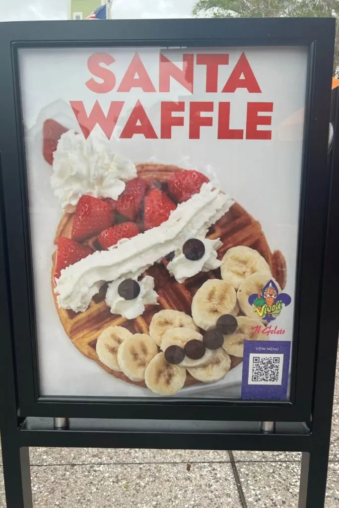 Photo of a sign for a Santa waffle with whipped cream, strawberries, bananas, and chocolate chips.