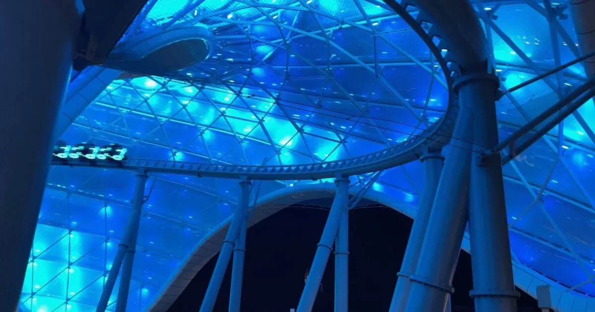 Horizontal photo of TRON Lightcycle Run at night, all lit up in blue.