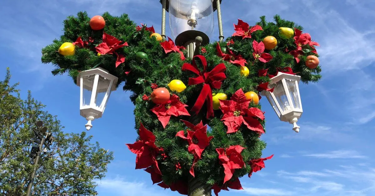 Closeup photo of a Mickey Mouse shaped Christmas wreath on a lamp post at Disney World.