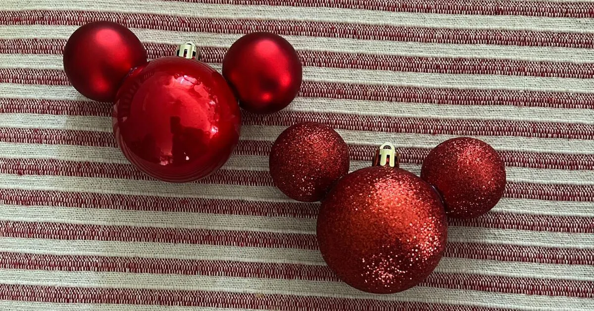 Closeup of two red, simple, handmade Mickey Mouse ornaments made with dollar store materials.