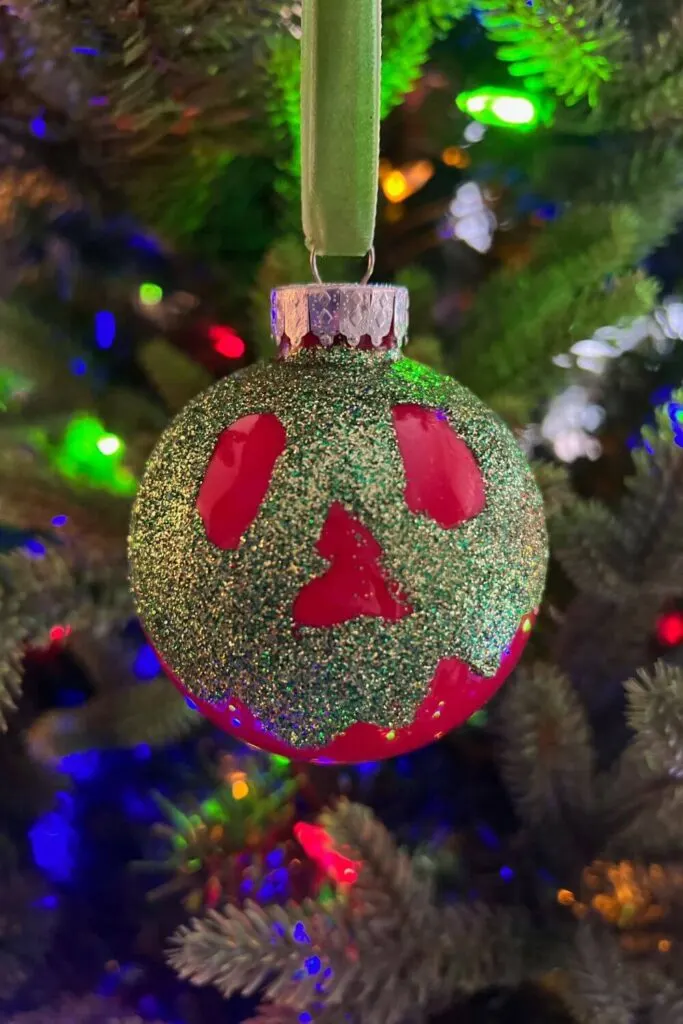 Closeup of a handmade ornament that looks like the poison apple from Snow White.