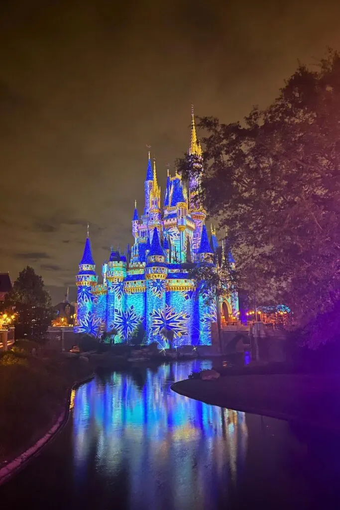 Photo of Cinderella's Castle from the side at night with snowflake laser projected onto it.