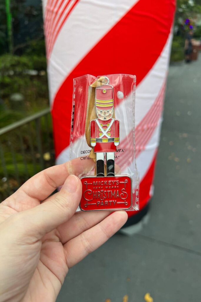 Closeup of an ornament featuring a metal toy soldier standing on a block that reads: Mickey's Very Merry Christmas Party.