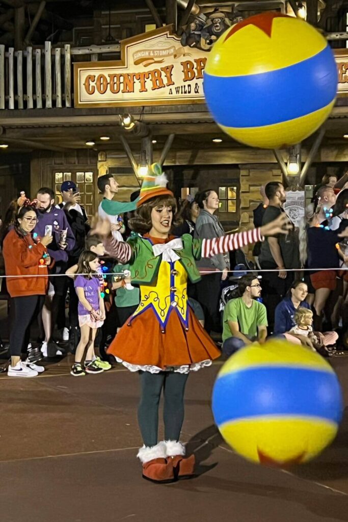 Photo of an entertainer throwing a ball during the parade at Mickey's Very Merry Christmas Party.