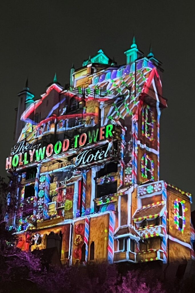 Photo of the Hollywood Tower Hotel at Hollywood Studios with a Christmas light projection show lighting it up like a gingerbread house.