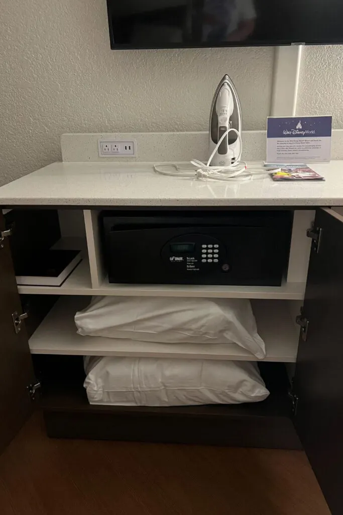 Photo of the typical dresser and storage at a Disney All Star resort, with an iron sitting on top.