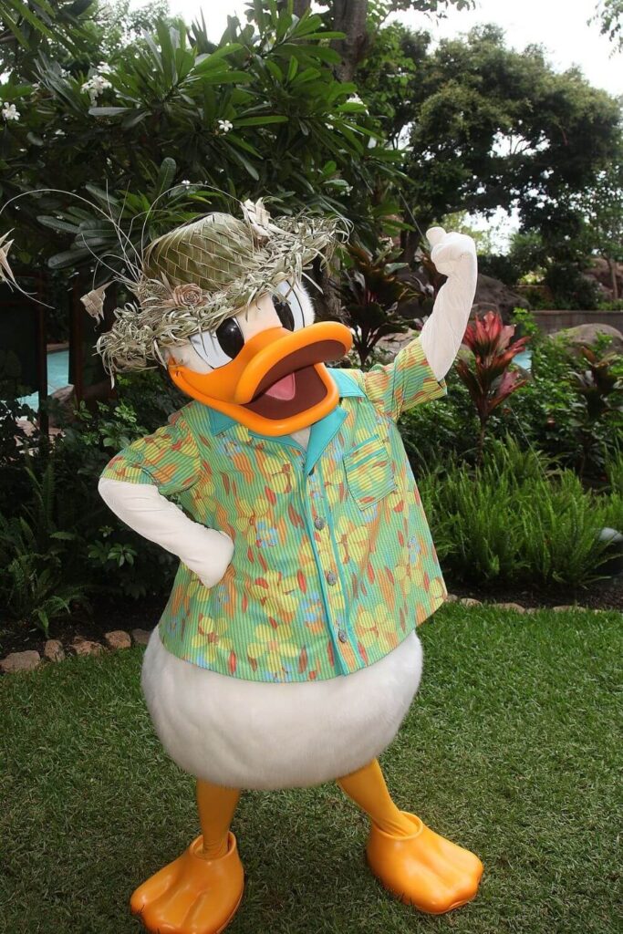 Photo of Donald Duck wearing a Hawaiian shirt and straw hat nearby the Aulani pool area.