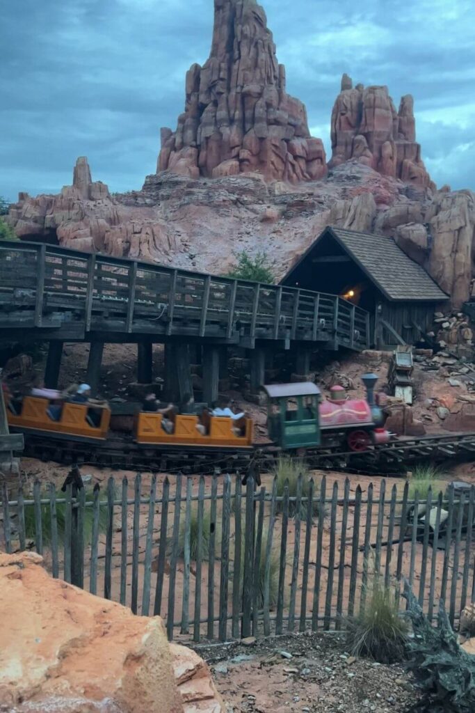 Photo of Big Thunder Mountain Railroad train car speeding by with the canyon in the background.