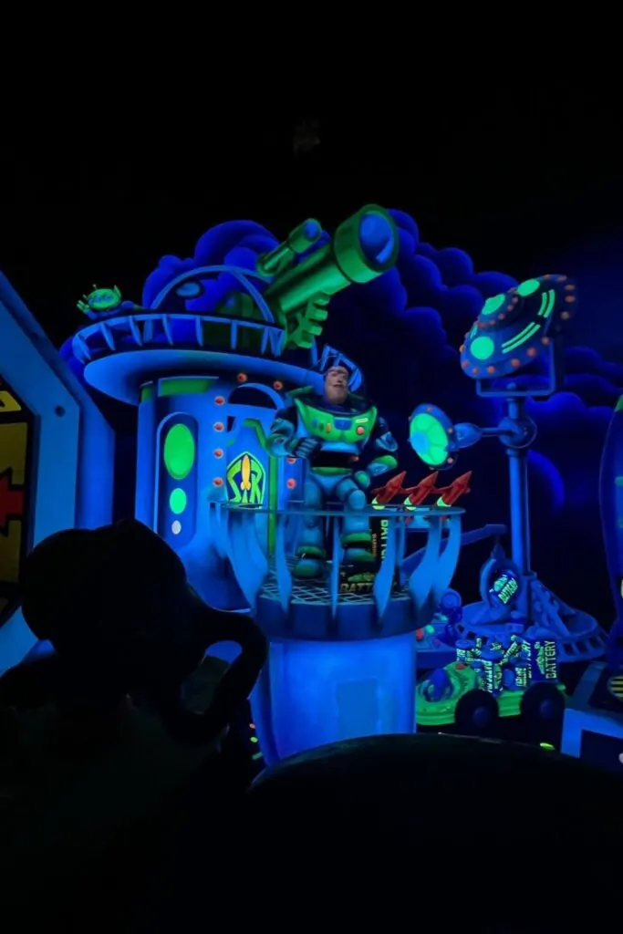 Photo inside Buzz Lightyear's Space Ranger Spin ride, with a Buzz animatronic greeting guests.