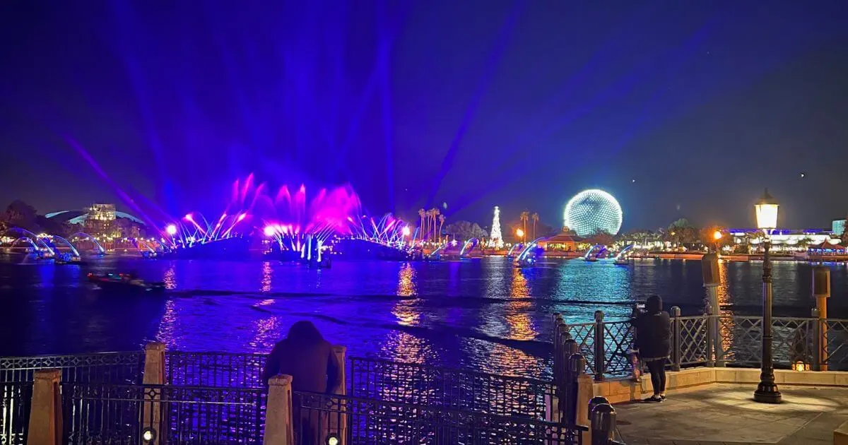 Photo of the World Showcase Lagoon after Luminous, with lights still shining and Spaceship Earth lit up in bright white lights.