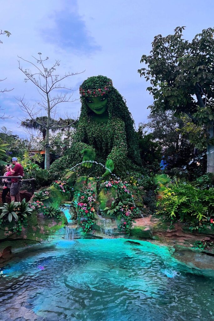 Photo of the life-like Te Fiti with a pond in the foreground at Journey of Water in Epcot.