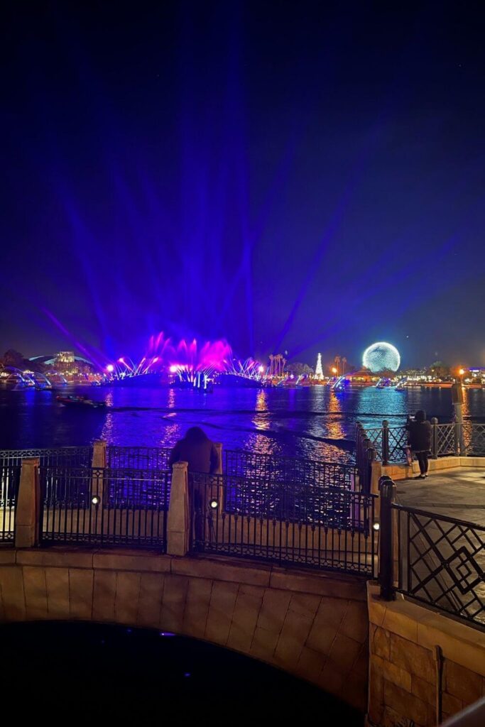 Photo of the World Showcase Lagoon at Epcot after Luminous, with lights and Spaceship Earth still lit up.