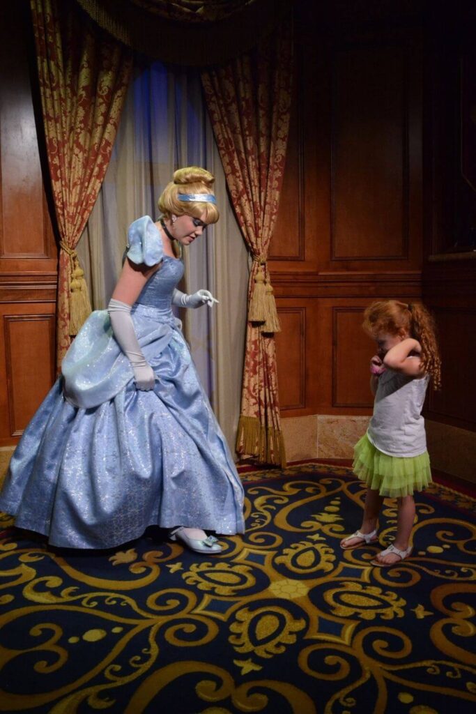 Photo of a young girl comparing shoes with Cinderella.