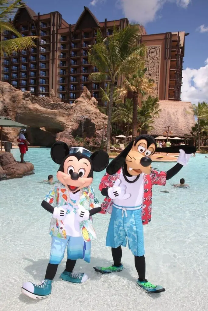 Photo of Mickey and Goofy standing in the Waikolohe Pool during the Shake-a-Shaka Pool Party at Aulani, a Disney Resort.