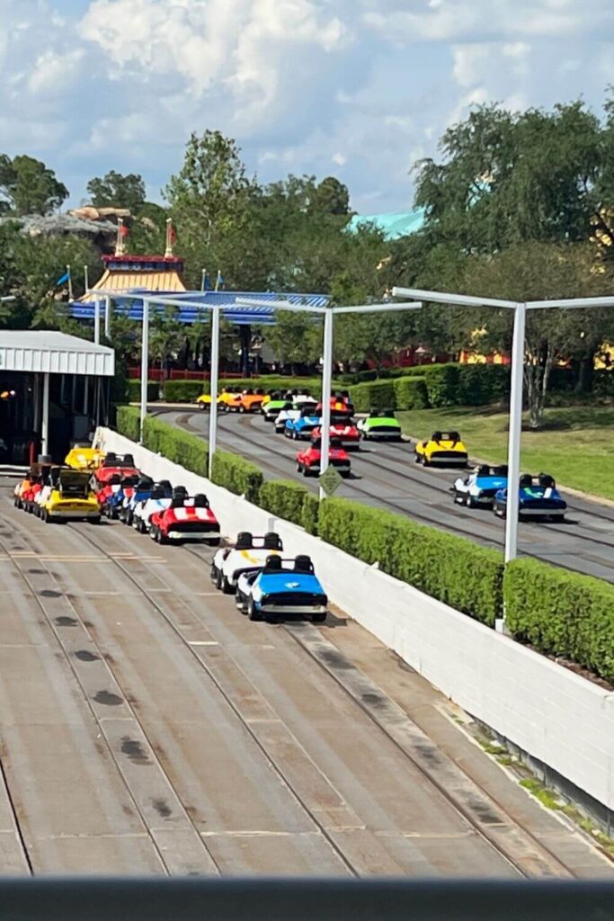Photo of Tomorrowland Speedway with colorful cars driving down the track.