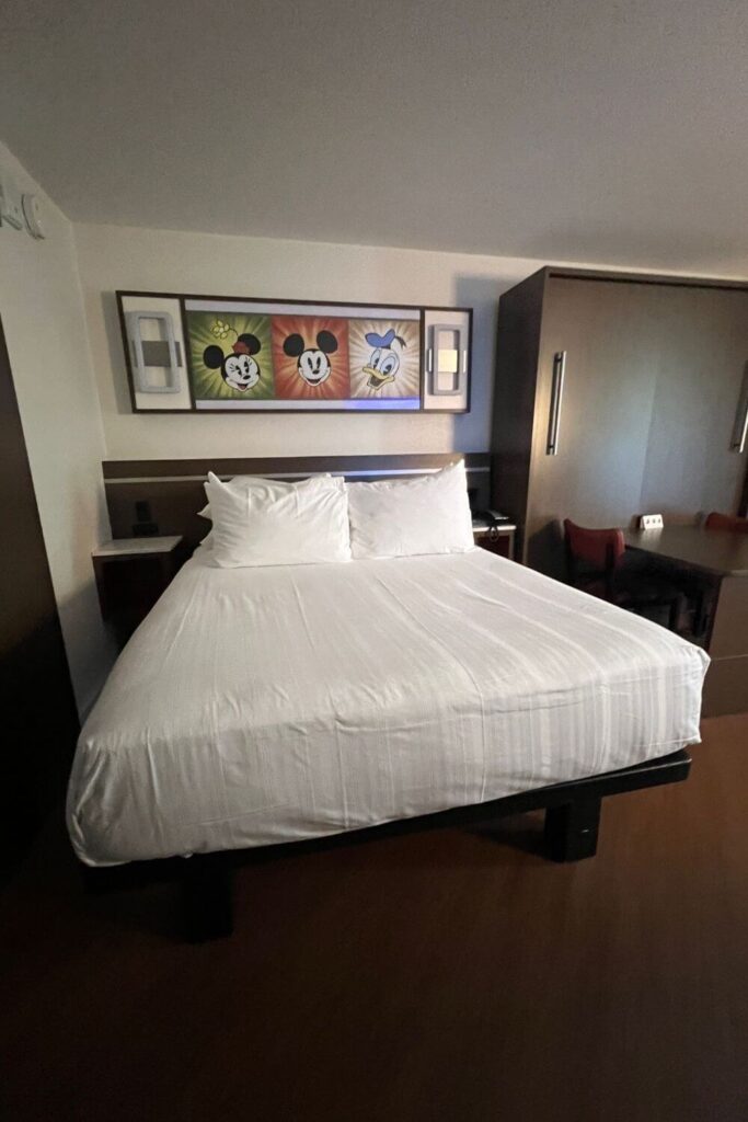 Photo of a Queen bed and a closed Queen-sized Murphy bed with a table and chairs.