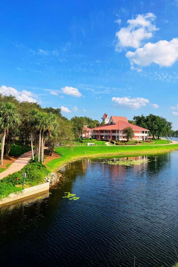 Photo of the sprawling Caribbean Beach Resort with a lake in the foreground and one of the guest room buildings in the background.