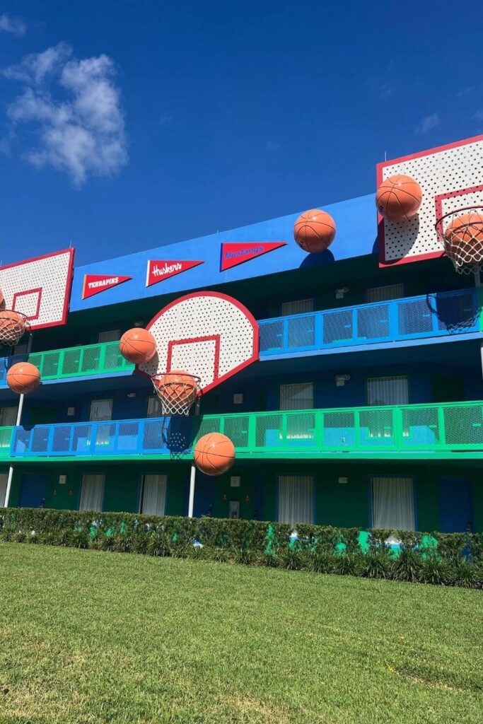 Photo of one of the Hoops Hotel buildings with giant basketball hoops, balls, and pennants adorned on the outside.