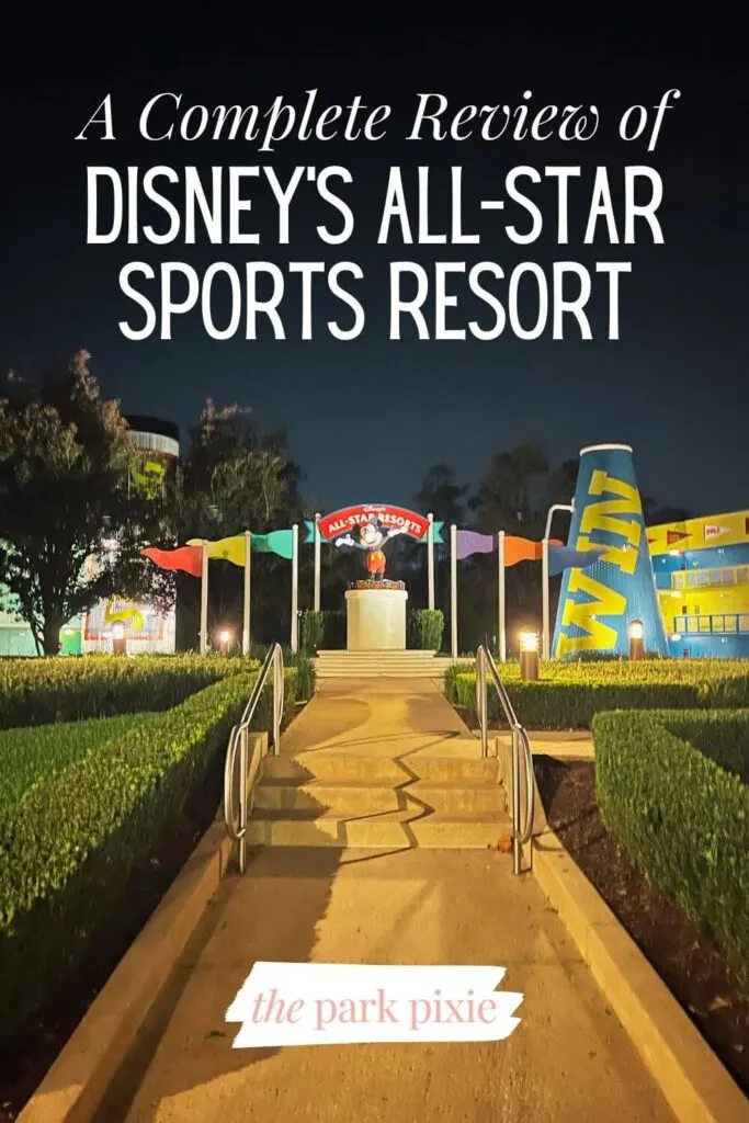 Photo of a large Mickey Mouse statue with pennants behind him at night. Text overlay reads: A Complete Review of Disney's All-Star Sports Resort.