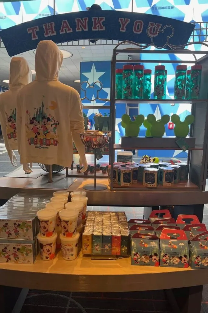 Photo of a merchandise display with Disney World hoodies, cups, snacks, and other goodies.