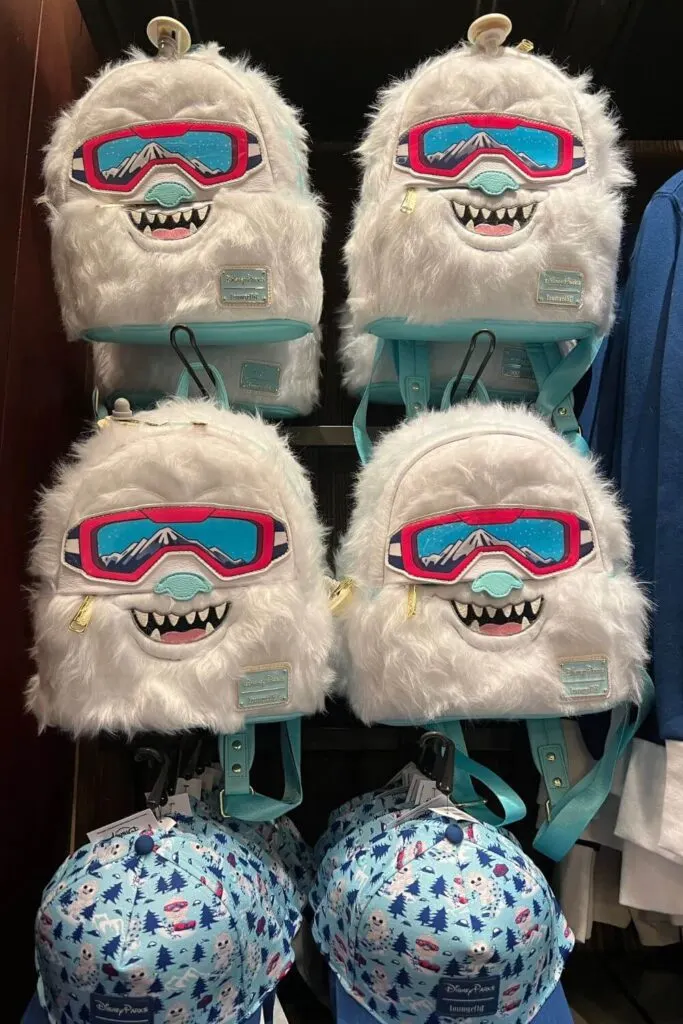 Photo of a merchandise rack with Yeti faux fur mini backpacks at the Expedition Everest gift shop.