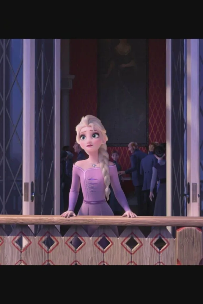 Still from Frozen, with Anna standing on a balcony looking out over Arendelle.