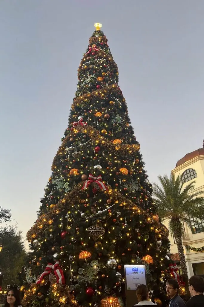 Photo of the main Christmas tree at Disney Springs during dusk.