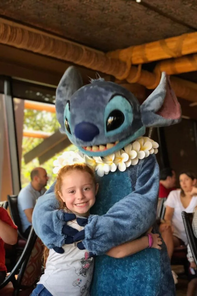 Photo of a young girl hugging Stitch at the Ohana Best Friends character breakfast at the Polynesian Resort.