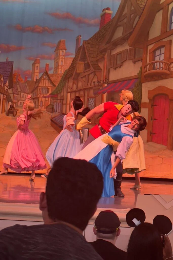 Photo of Gaston dipping Belle while dancers prance in the background during a performance of Beauty & the Beast: Live on Stage at Hollywood Studios.