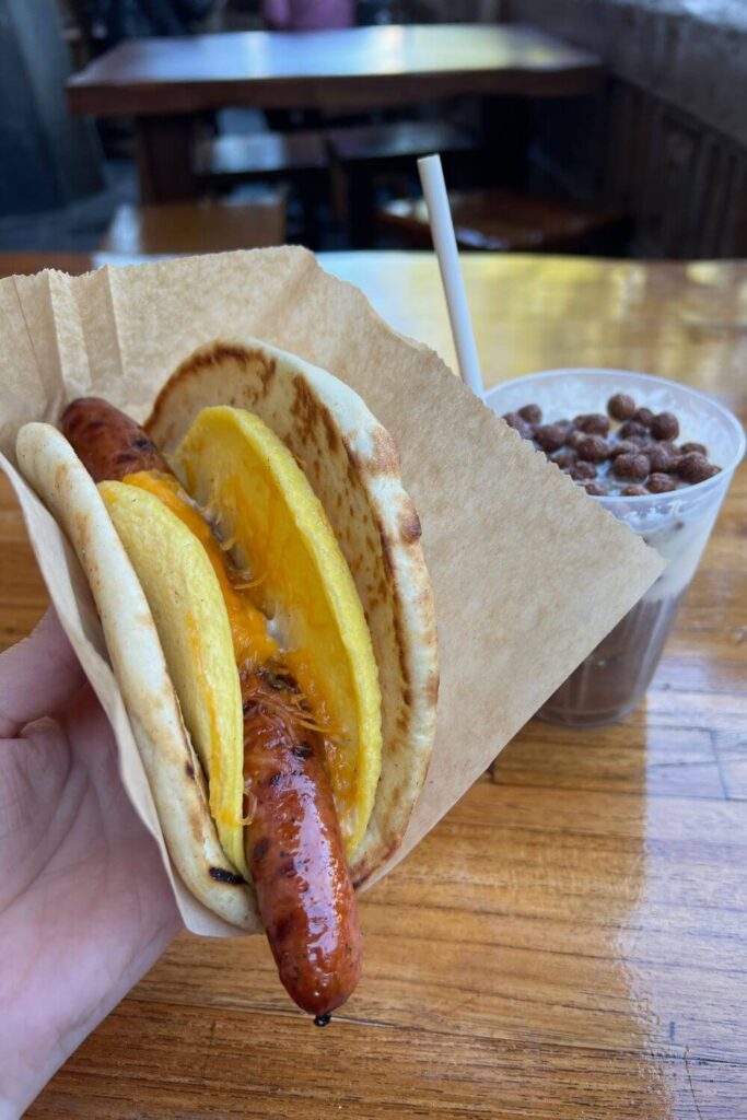 Photo of a breakfast ronto wrap with a black caf cold brew in the background.