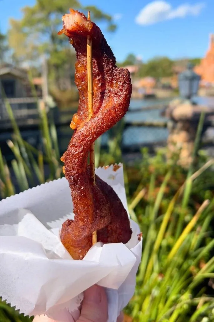 Closeup of a thick slab of candied bacon on a skewer from Westward Ho.
