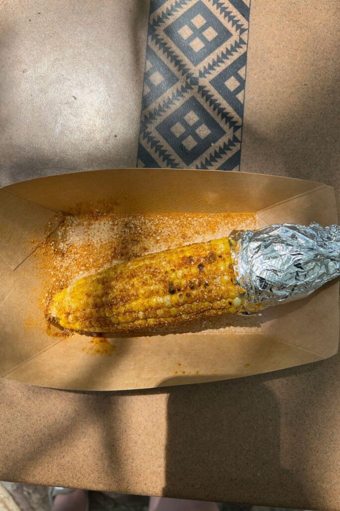 Photo of a basket with a grilled corn on the cob with African spices in a basket on top of a table in the Africa section of Disney's Animal Kingdom theme park.