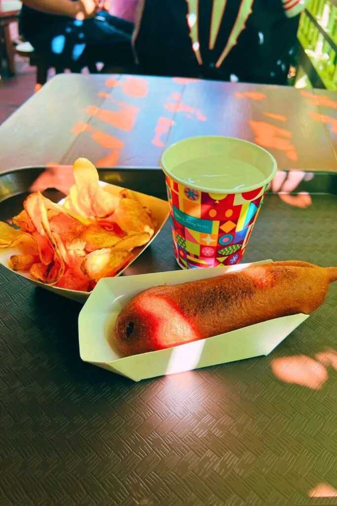 Photo of a giant hand-dipped corn dog and handmade chips from Sleepy Hollow at Magic Kingdom.