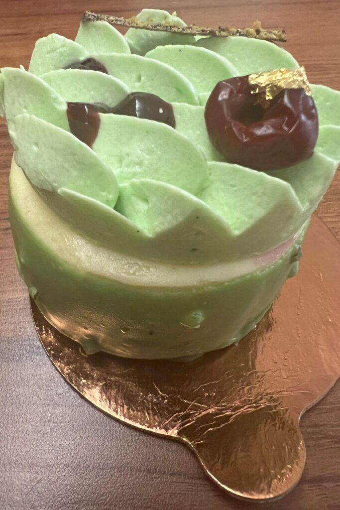 Closeup of a pistachio cherry petit cake from Amorette's Patisserie.