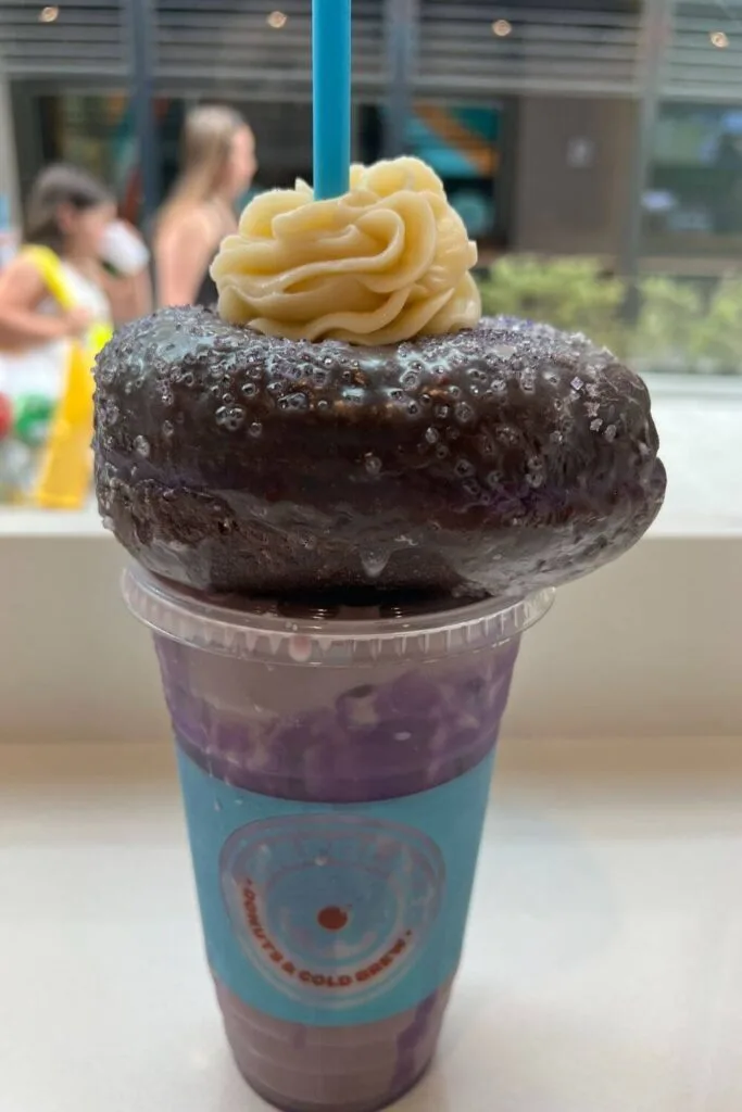 Photo of purple ube chai tea with a purple ube donut stacked on top.