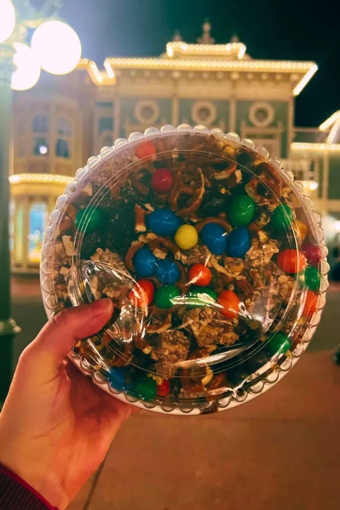 Photo of a large bowl of Willie's Sweetest Spoon Recipe Popcorn Mix with Magic Kingdom's Main Street in the background.
